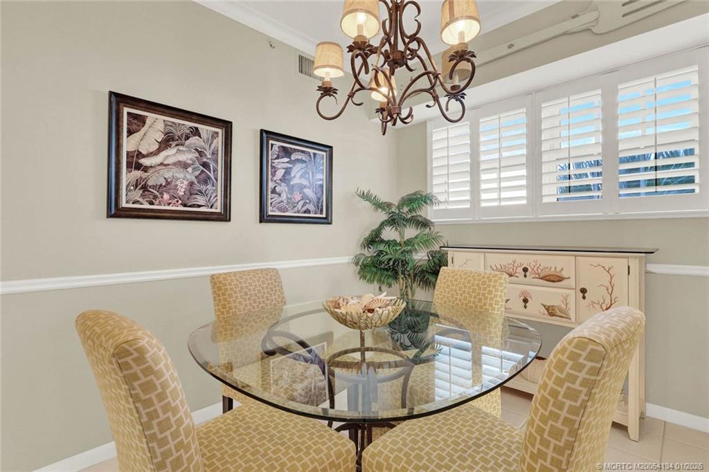 5700 Northeast Island Cove Way, Unit 4301 Stuart, FL 34996 - Photo 15 of 45 a dining room with furniture and window