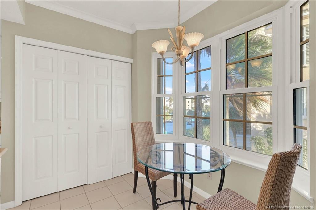 5700 Northeast Island Cove Way, Unit 4301 Stuart, FL 34996 - Photo 22 of 45 a view of a dining room with furniture wooden floor and chandelier