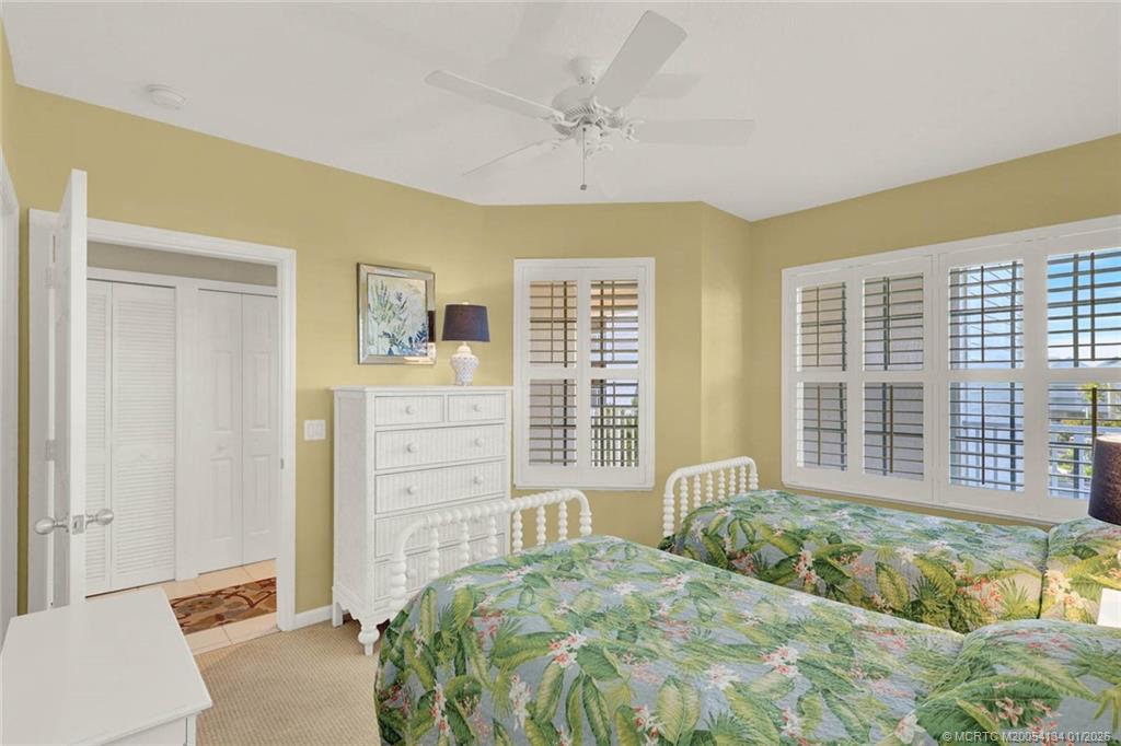 5700 Northeast Island Cove Way, Unit 4301 Stuart, FL 34996 - Photo 39 of 45 a bedroom with a bed a dresser and a large window