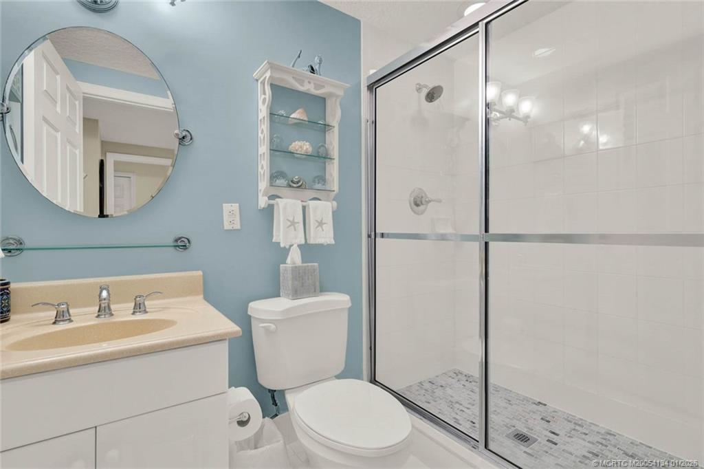 5700 Northeast Island Cove Way, Unit 4301 Stuart, FL 34996 - Photo 40 of 45 a bathroom with a toilet a sink and a mirror