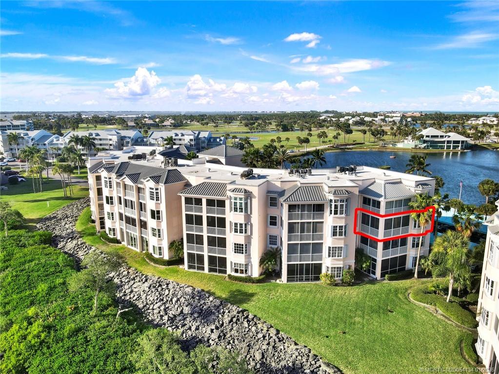 5700 Northeast Island Cove Way, Unit 4301 Stuart, FL 34996 - Photo 6 of 45 a view of a large building with a yard