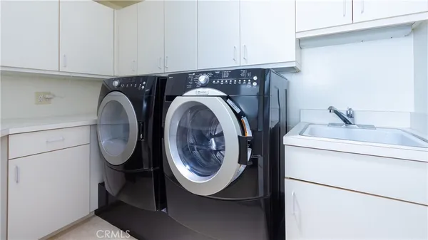 a view of a patio with couches table and chairs under an umbrella