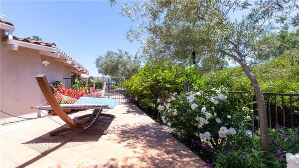 a view of a white house with a big yard and potted plants