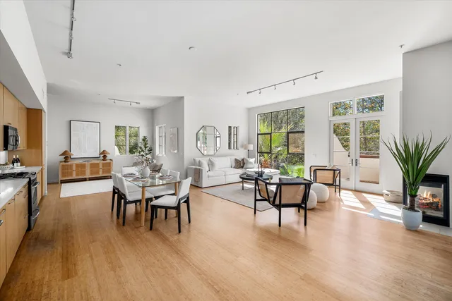 a living room with furniture floor to ceiling window and wooden floor