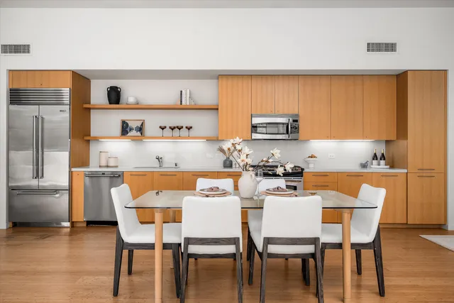 a kitchen with a dining table chairs and a refrigerator
