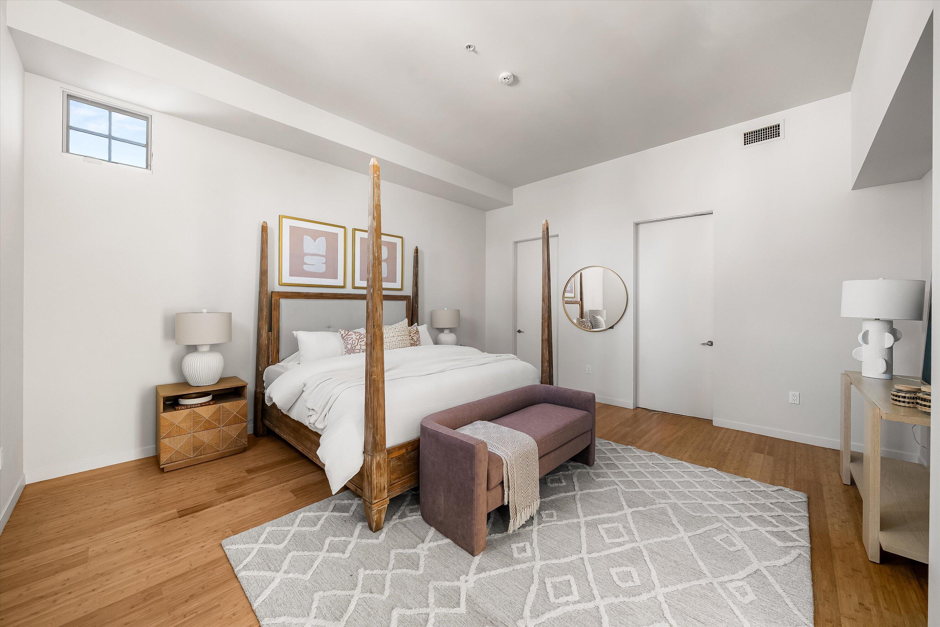 401 Chapala Street, Unit 214 Santa Barbara, CA 93101 - Photo 17 of 31 a bedroom with a bed a rug and wooden floor