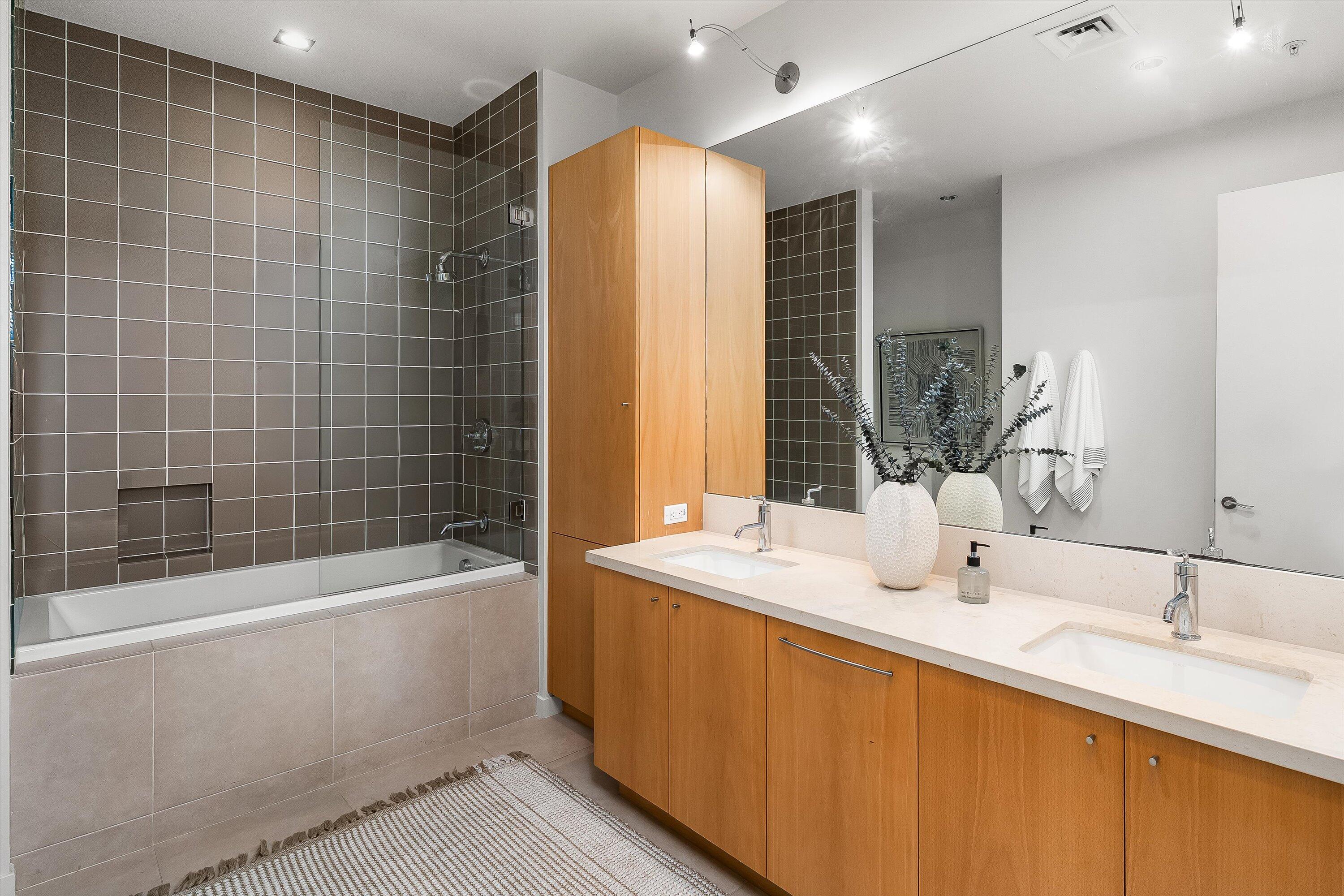 401 Chapala Street, Unit 214 Santa Barbara, CA 93101 - Photo 19 of 31 a bathroom with a double vanity sink and a bathtub