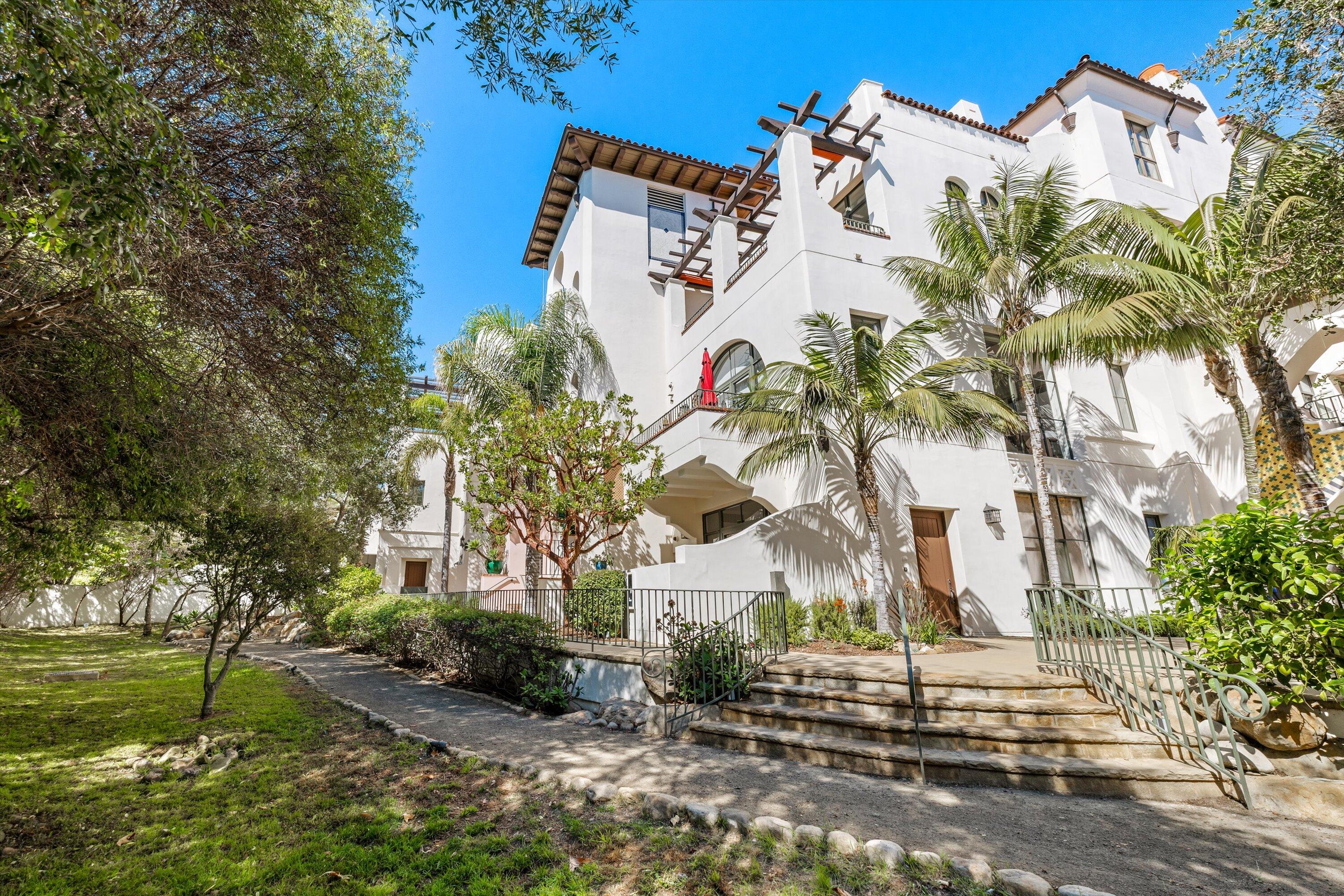 401 Chapala Street, Unit 214 Santa Barbara, CA 93101 - Photo 26 of 31 a view of a white house with a yard and potted plants