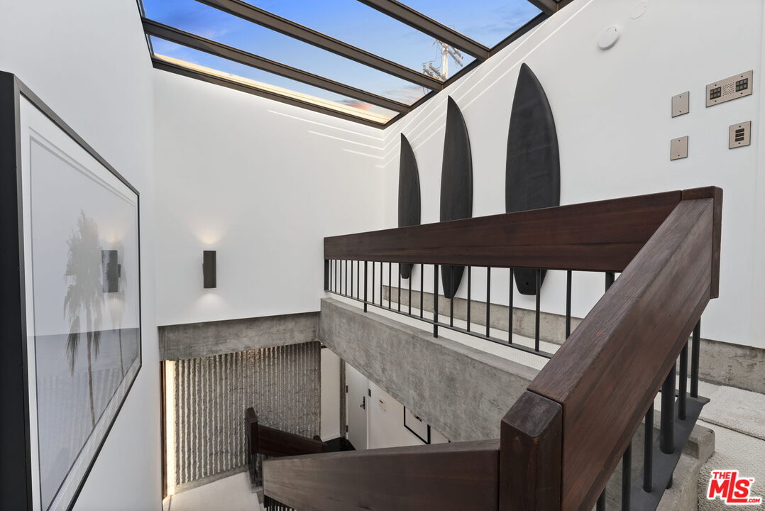 407 Upper Mesa Road Santa Monica, CA 90402 - Photo 12 of 54 a view of staircase with lots of frames on wall and a window
