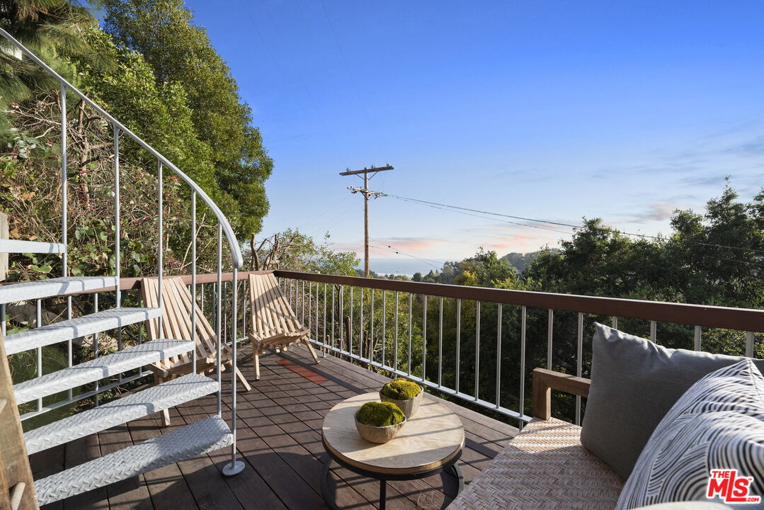407 Upper Mesa Road Santa Monica, CA 90402 - Photo 43 of 54 a view of a balcony with two chairs and a wooden deck