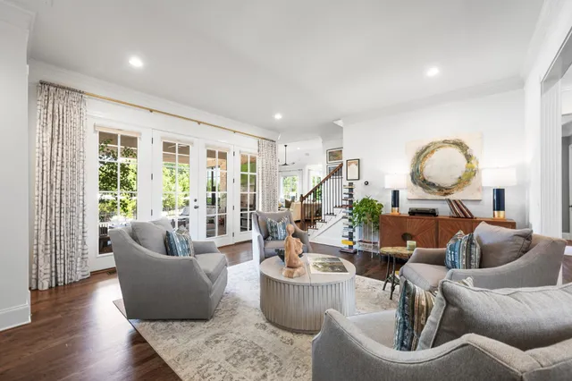 a kitchen with stainless steel appliances a stove a sink a refrigerator white cabinets and wooden floor