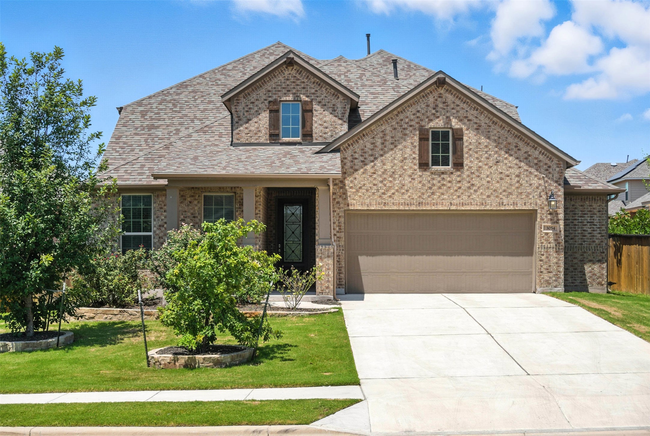 3054 Columbus Loop Round Rock, TX 78665 - Photo 3 of 40 French country style house with brick siding, concrete driveway, and a shingled roof