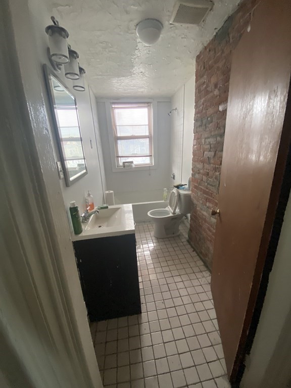 29 East Cottage Street Boston, MA 02125 - Photo 12 of 13 a bathroom with a sink and mirror with bathtub