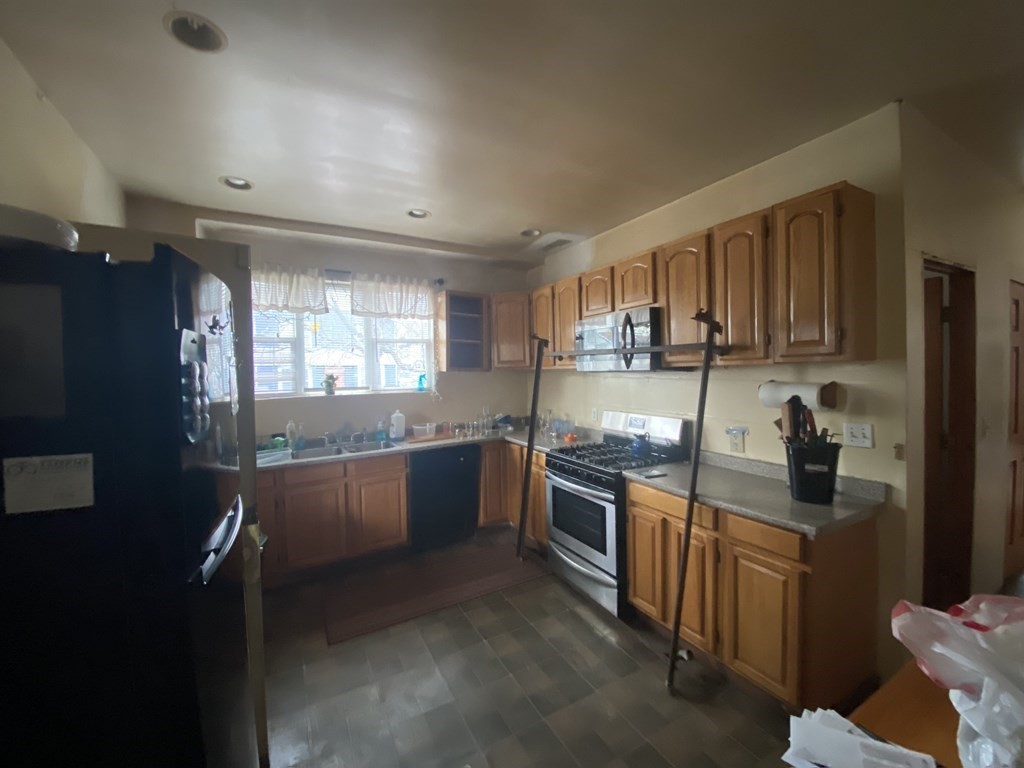 29 East Cottage Street Boston, MA 02125 - Photo 5 of 13 a kitchen with stainless steel appliances granite countertop a stove a sink and a refrigerator