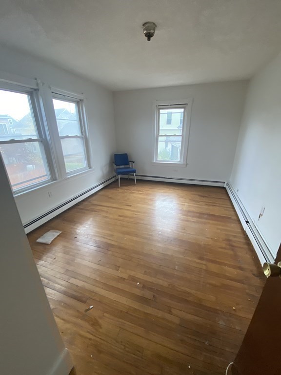 29 East Cottage Street Boston, MA 02125 - Photo 9 of 13 wooden floor in an empty room with a window