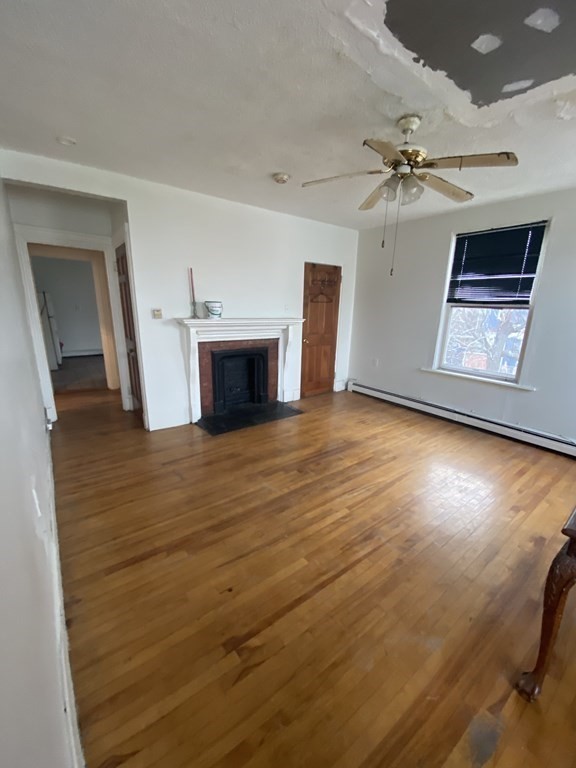 29 East Cottage Street Boston, MA 02125 - Photo 10 of 13 wooden floor in an empty room with a fireplace