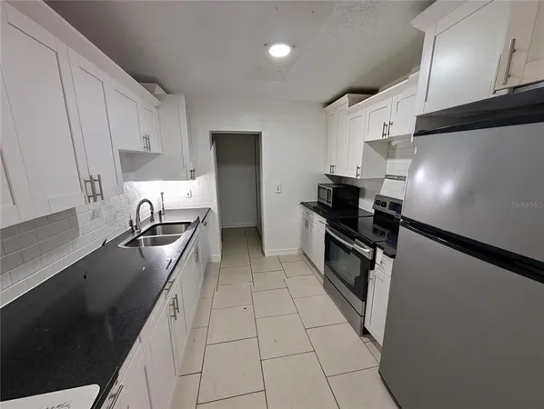 a kitchen with stainless steel appliances a refrigerator a sink a stove and cabinets