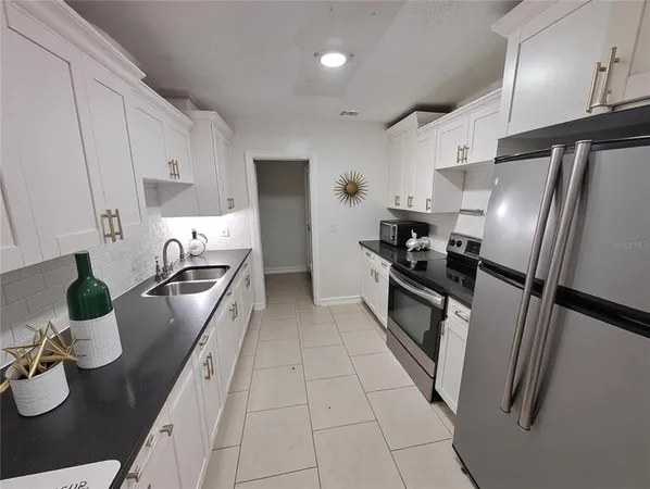 a kitchen with sink a stove and refrigerator