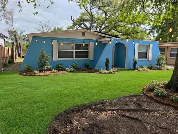 a view of a house with a yard and sitting area