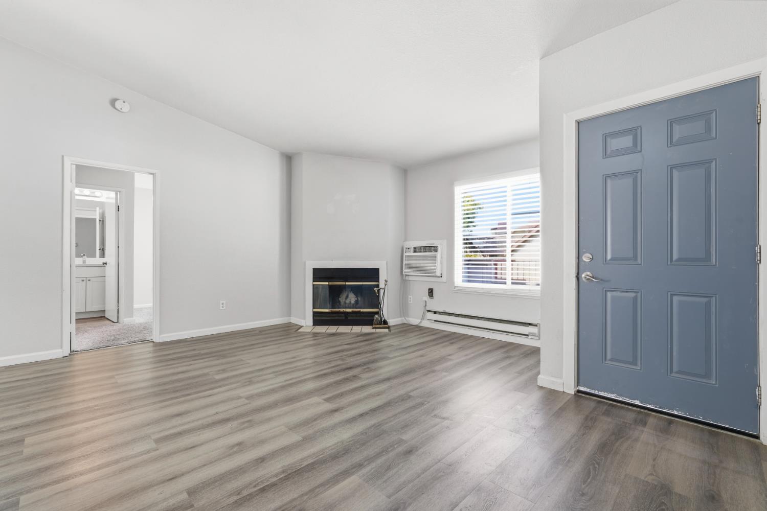 3 Lancaster Circle, Unit 209 Bay Point, CA 94565 - Photo 2 of 30 an empty room with wooden floor fireplace and windows