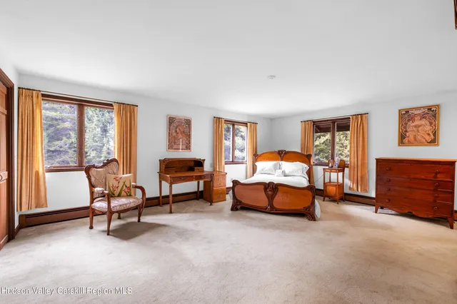 a bedroom with furniture and a large window