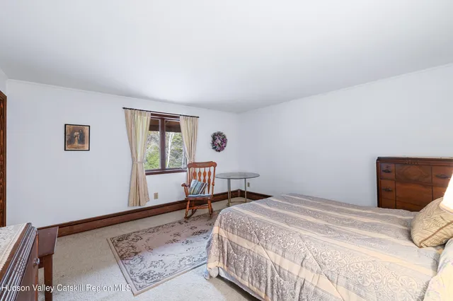 a bedroom with a bed a table and chair