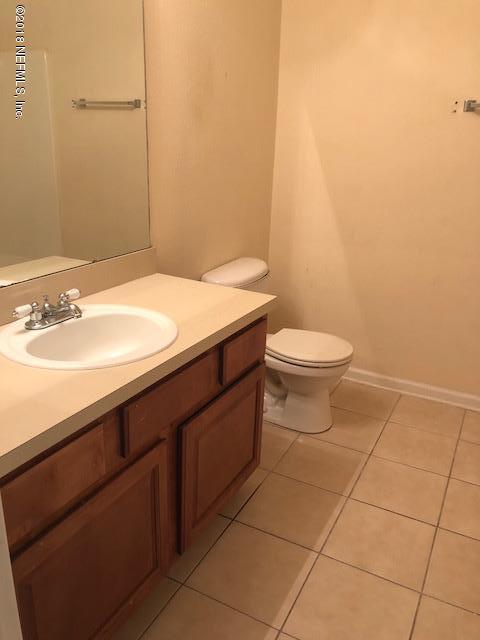 7920 Merrill Road, Unit 1813 Jacksonville, FL 32277 - Photo 9 of 9 a bathroom with a sink a toilet and a mirror