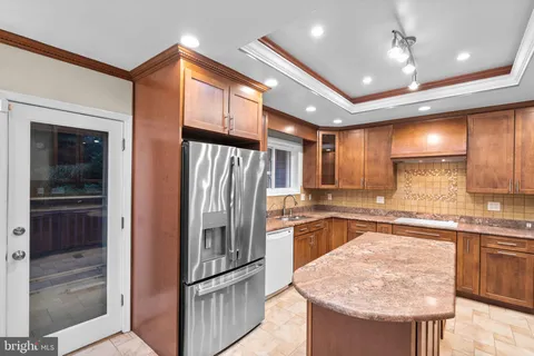 a kitchen with stainless steel appliances granite countertop a sink refrigerator and cabinets