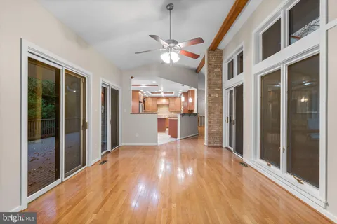 a view of an empty room with a window and wooden floor