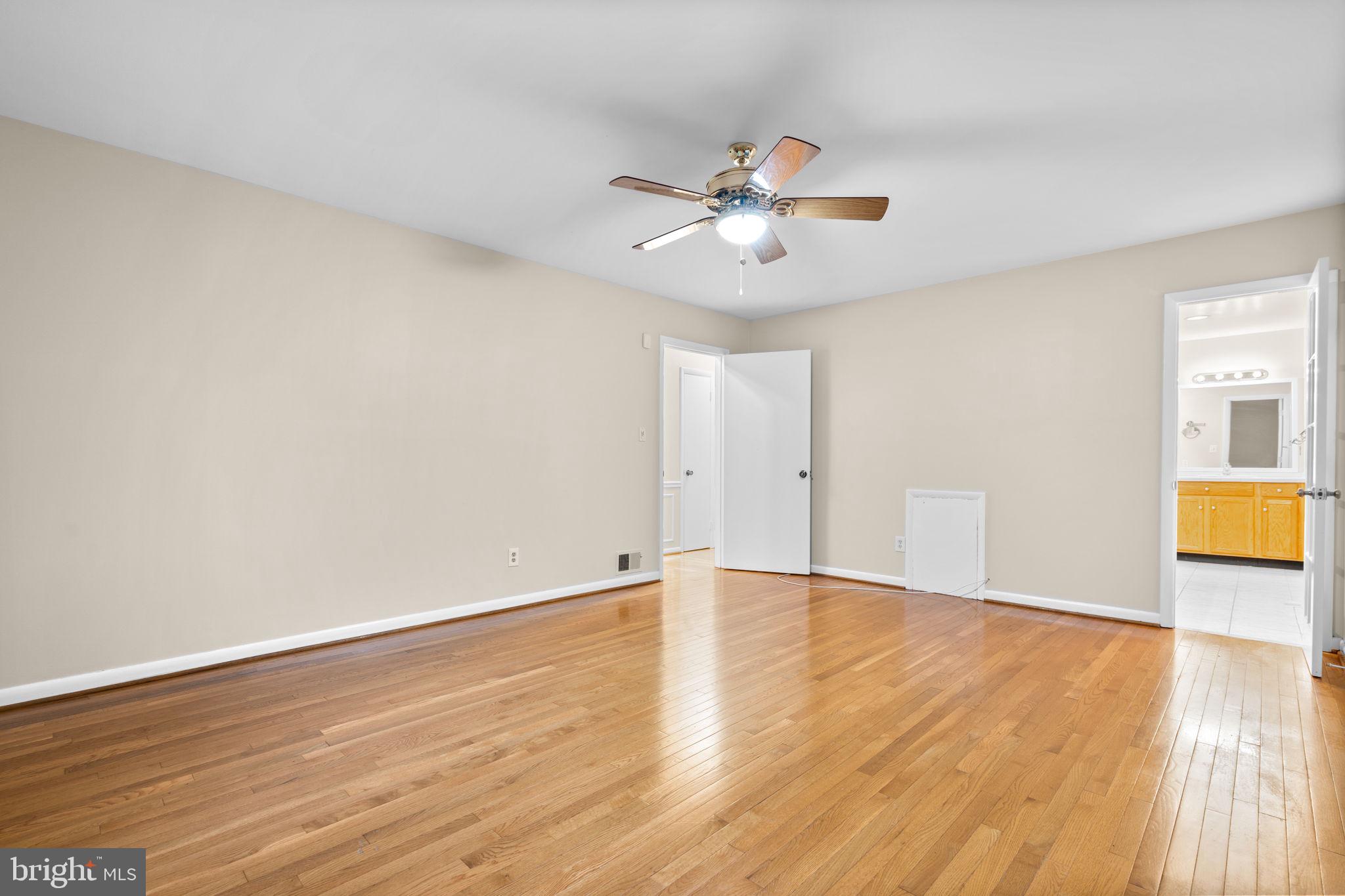 7711 Arrowood Court Bethesda, MD 20817 - Photo 21 of 59 a view of an empty room with wooden floor and a ceiling fan