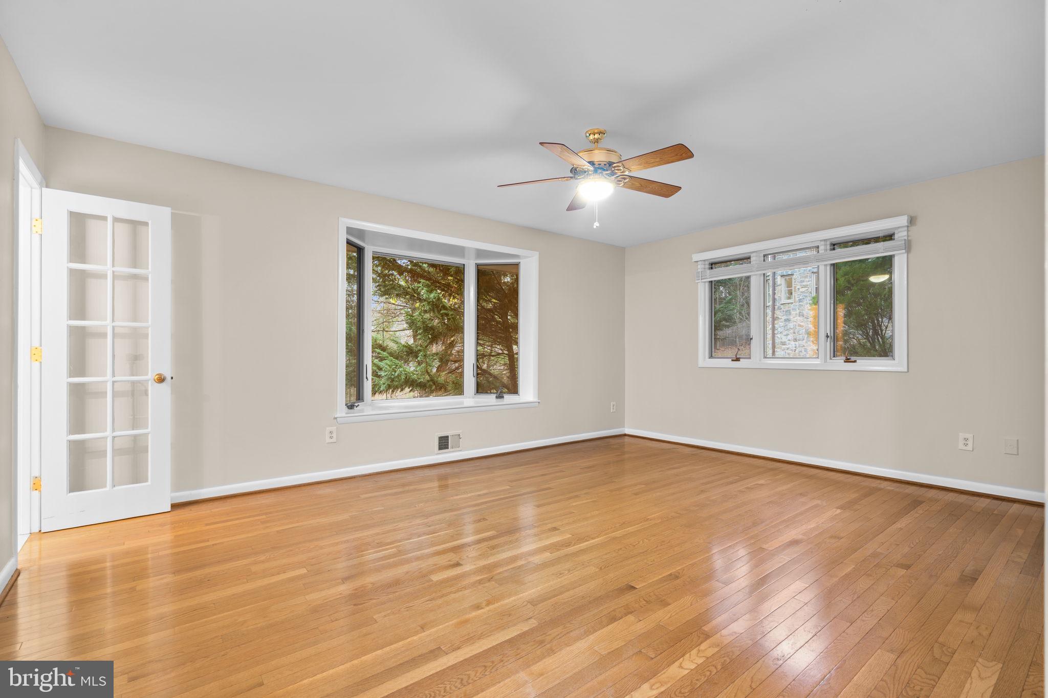 7711 Arrowood Court Bethesda, MD 20817 - Photo 22 of 59 a view of an empty room with a window and wooden floor