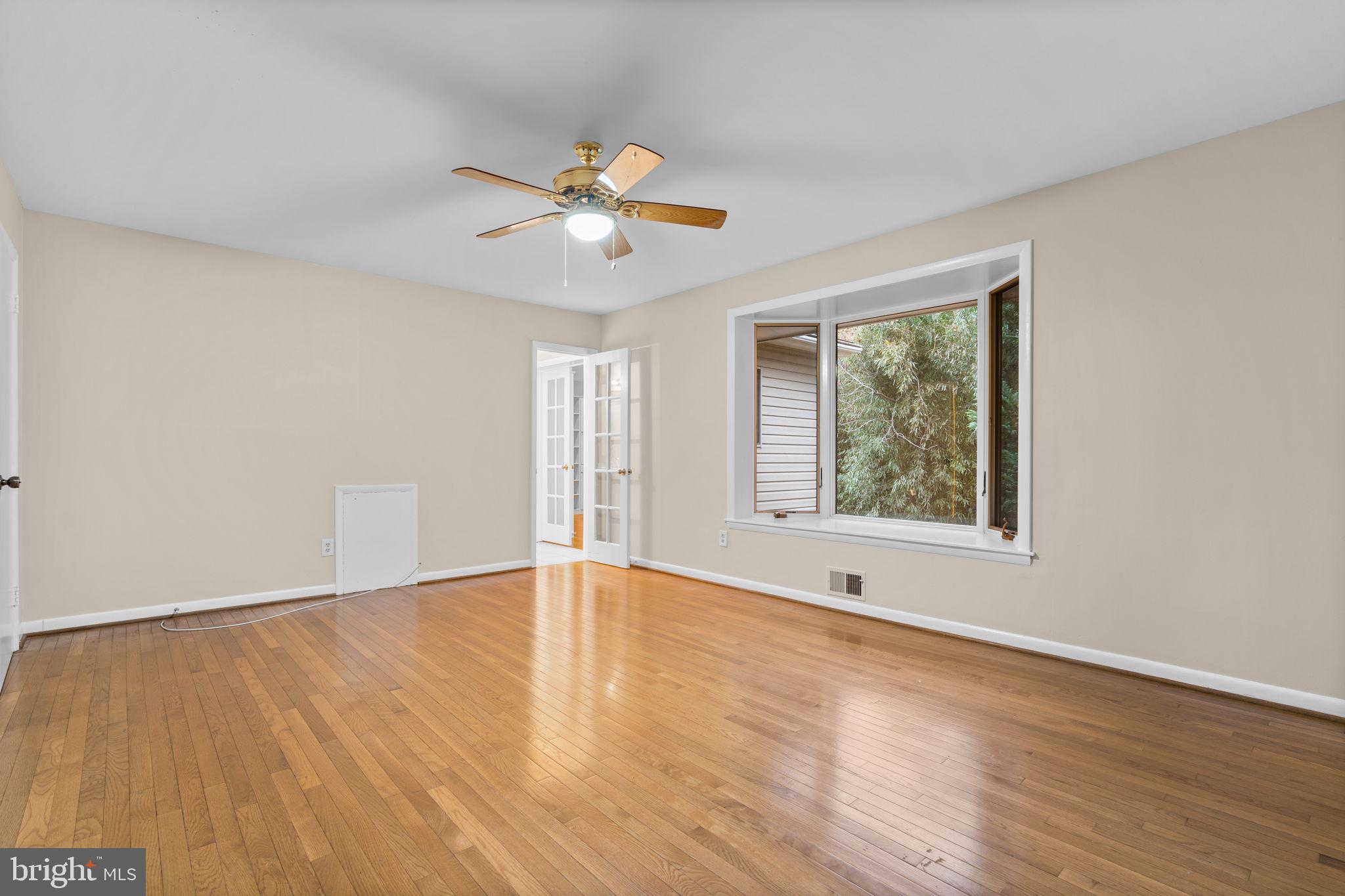 7711 Arrowood Court Bethesda, MD 20817 - Photo 23 of 59 a view of an empty room with wooden floor and a window
