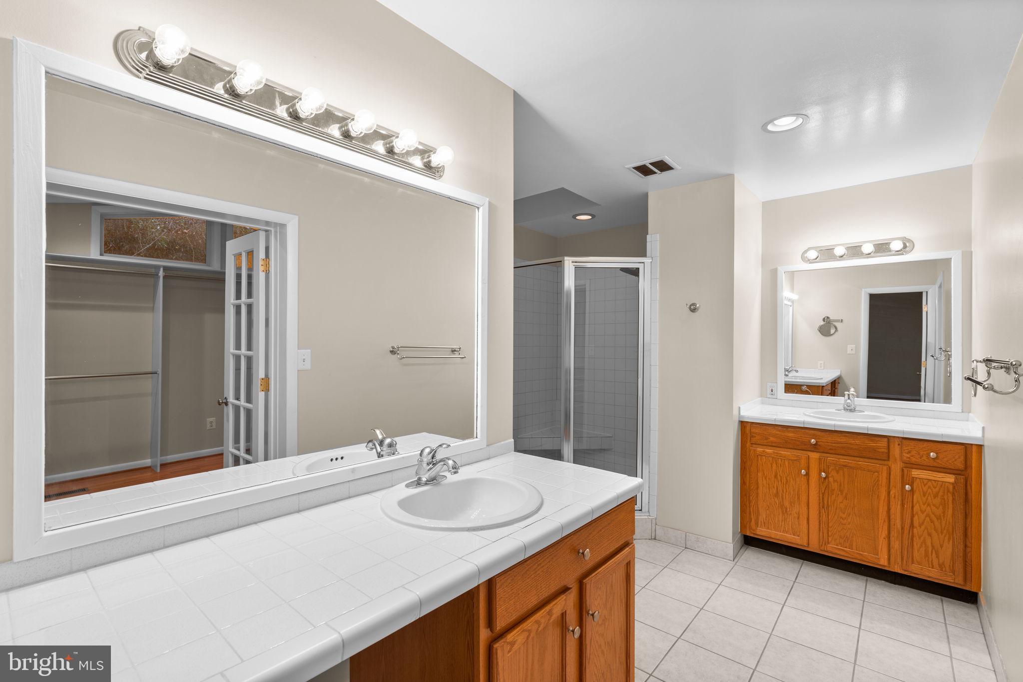 7711 Arrowood Court Bethesda, MD 20817 - Photo 24 of 59 a bathroom with a sink double vanity and a mirror