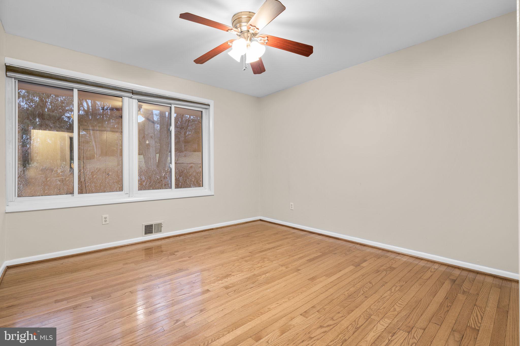 7711 Arrowood Court Bethesda, MD 20817 - Photo 31 of 59 a view of an empty room with window and wooden floor