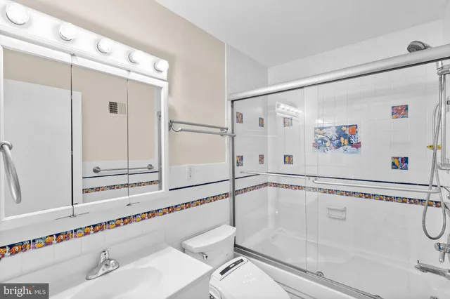 an empty room with wooden floor fireplace and windows