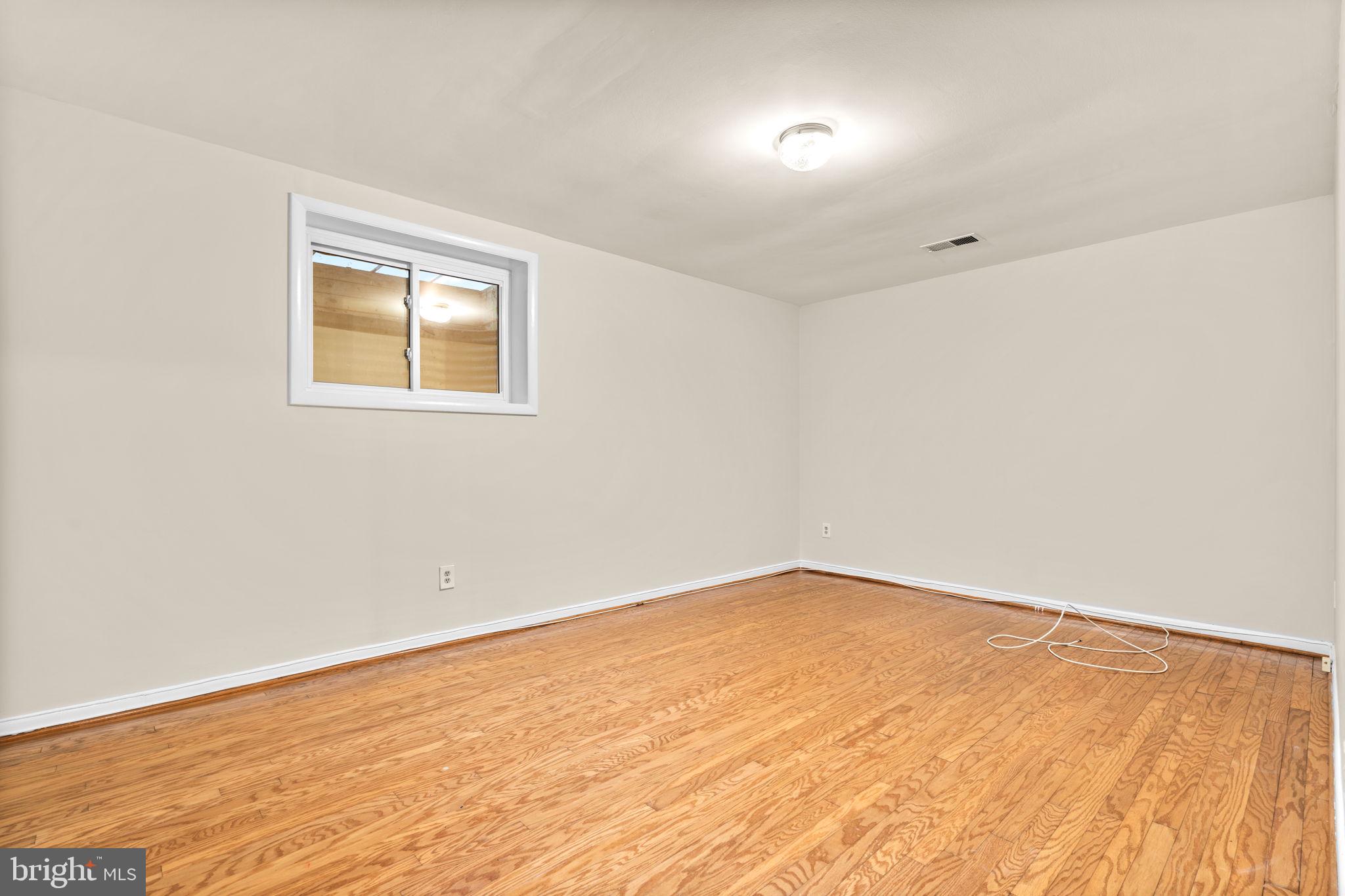 7711 Arrowood Court Bethesda, MD 20817 - Photo 46 of 59 an empty room with wooden floor and windows