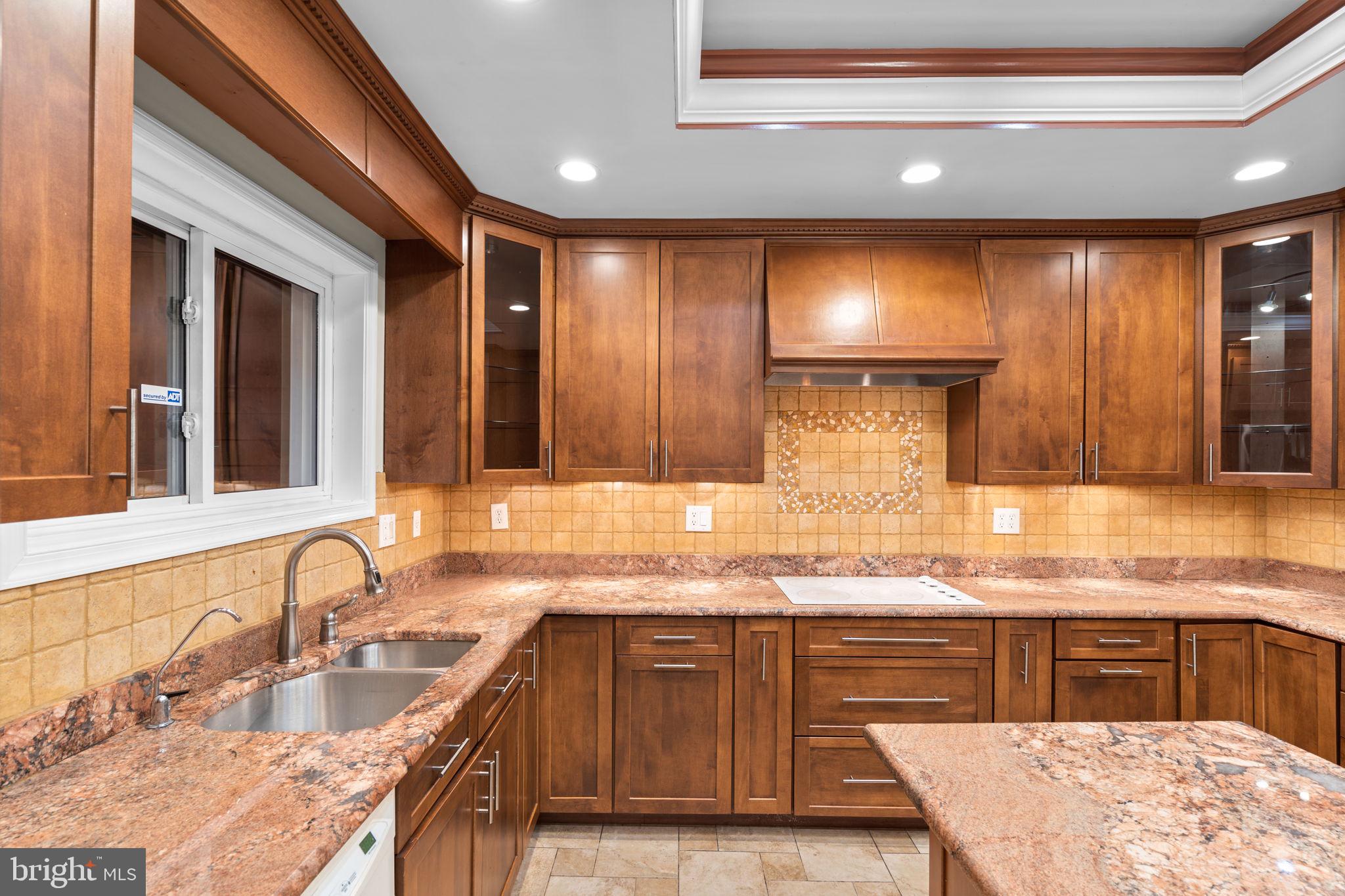7711 Arrowood Court Bethesda, MD 20817 - Photo 9 of 59 a kitchen with granite countertop a sink and a stove