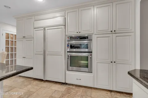 a kitchen with white cabinets and refrigerator