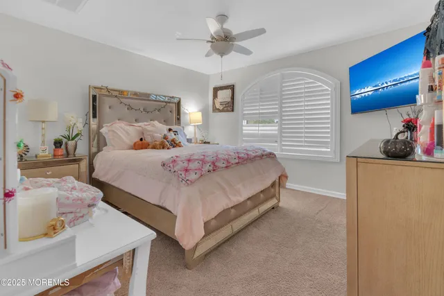 a bedroom with a bed and a dresser with wooden floor