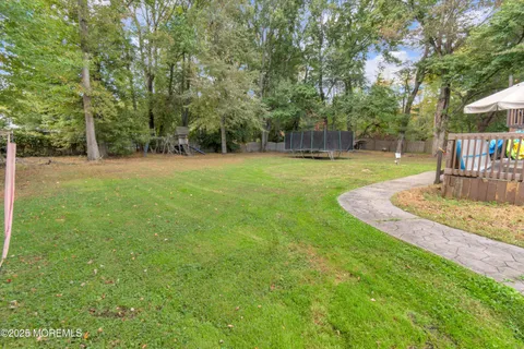a view of a house with a big yard and large trees