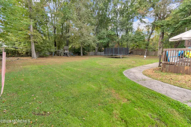 a view of a house with a big yard and large trees