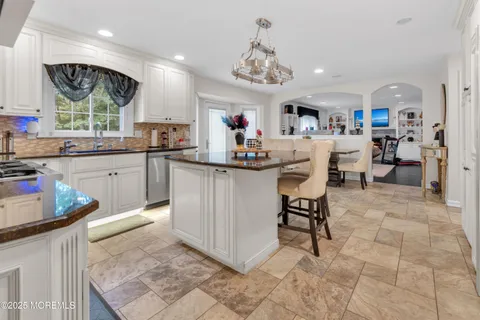 a kitchen with stainless steel appliances granite countertop a sink and a refrigerator