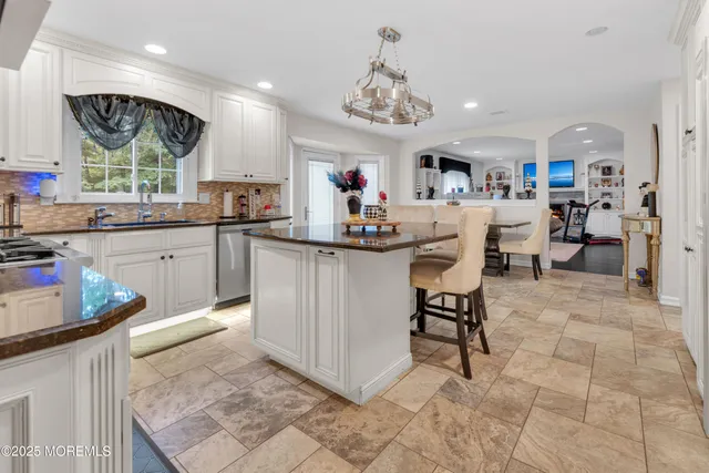 a kitchen with stainless steel appliances granite countertop a sink and a refrigerator
