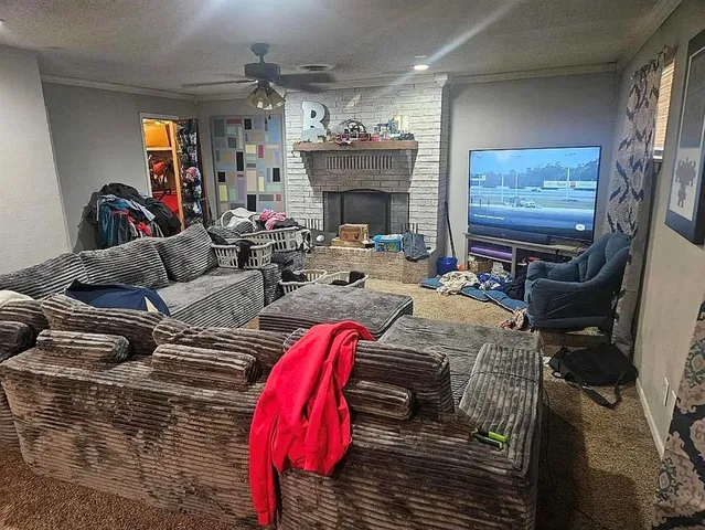 a living room with furniture a fireplace and flat screen tv