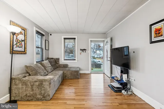 a living room with furniture flat screen tv and wooden floor
