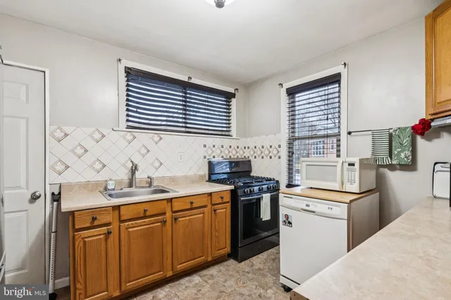 a kitchen with stainless steel appliances a sink stove and cabinets