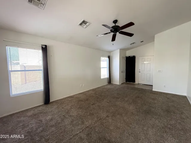 a view of a livingroom with a ceiling fan and window