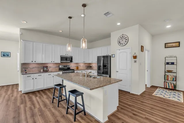 a view of a dining room with furniture a chandelier and wooden floor