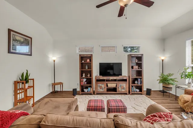 a spacious bathroom with a granite countertop sink a toilet a mirror and shower