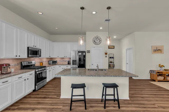 a kitchen with granite countertop a sink stove and refrigerator